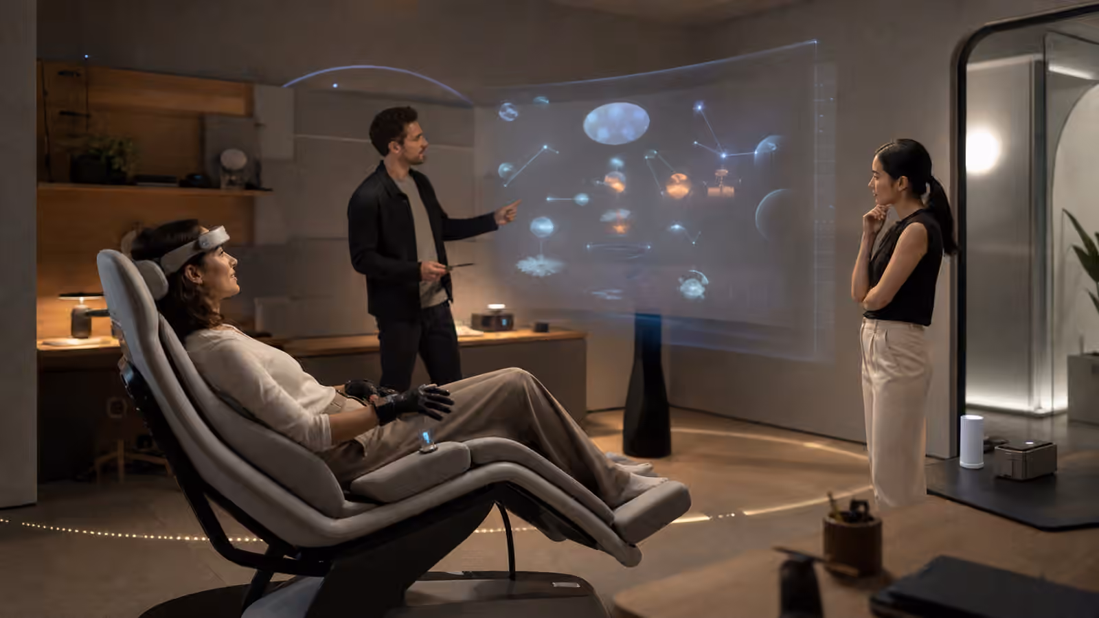 A calm workplace full dive room with an immersed participant, respectful facilitators, and an abstract shared workspace display.